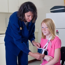 School nurse puts student's arm in a sling